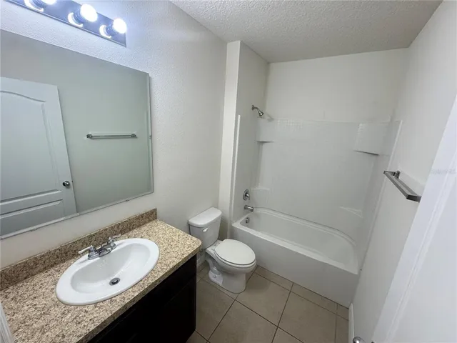 a bathroom with a granite countertop sink a toilet and shower