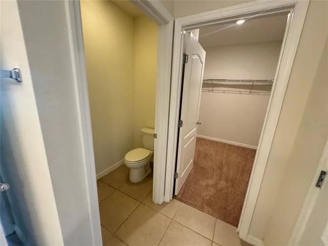 a bathroom with a granite countertop toilet and a sink