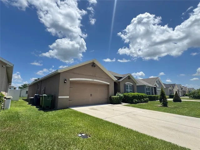 a front view of a house with a garden and yard