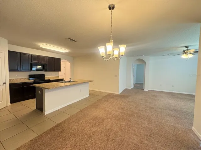 a large kitchen with kitchen island granite countertop stainless steel appliances