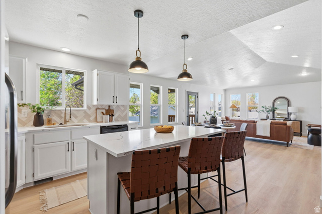 2460 Allison Way Syracuse, UT 84075 - Photo 6 of 24 Open-concept kitchen and living area featuring wood-finish flooring, recessed lighting, and a vaulted ceiling