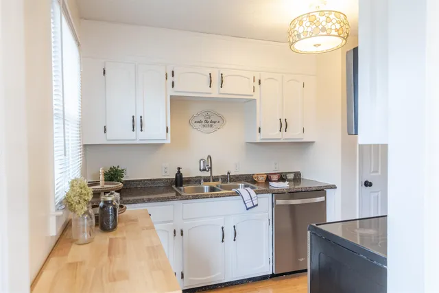 a kitchen with stainless steel appliances granite countertop a sink a stove and cabinets