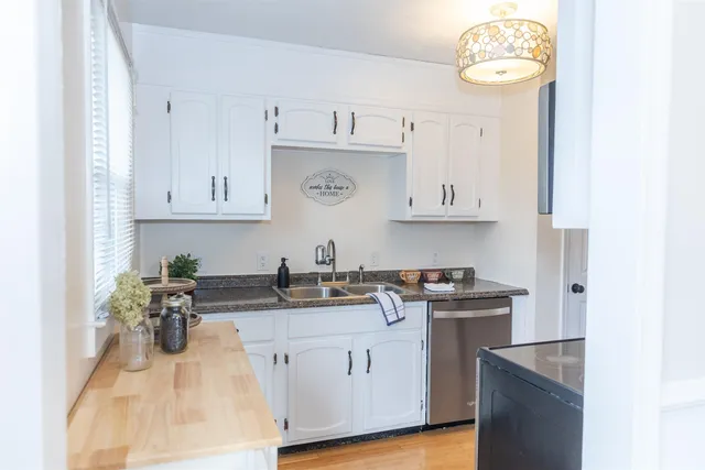 a kitchen with stainless steel appliances granite countertop a sink a stove and cabinets