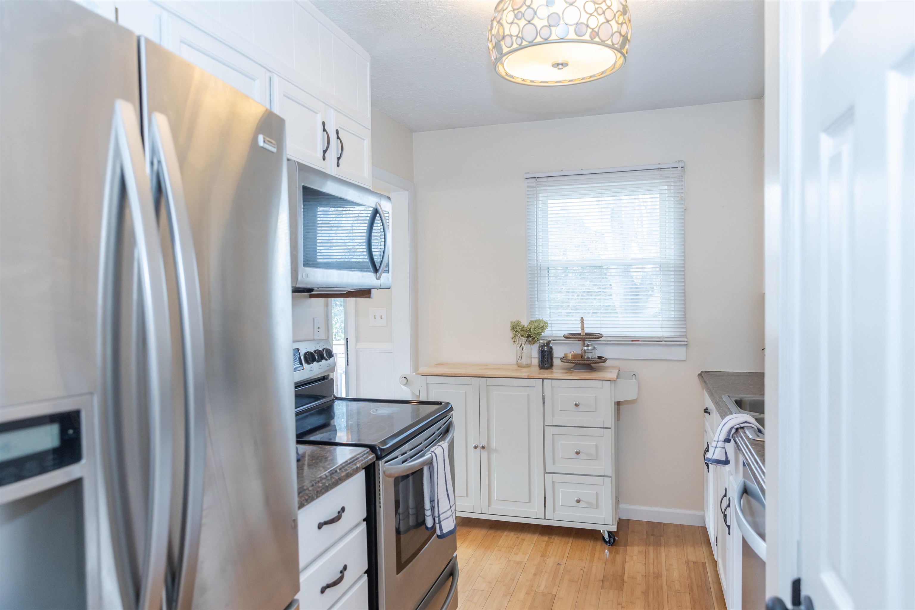 303 Summit Street Lexington, VA 24450 - Photo 15 of 58 a kitchen with stainless steel appliances granite countertop a refrigerator a stove and a sink with wooden floor
