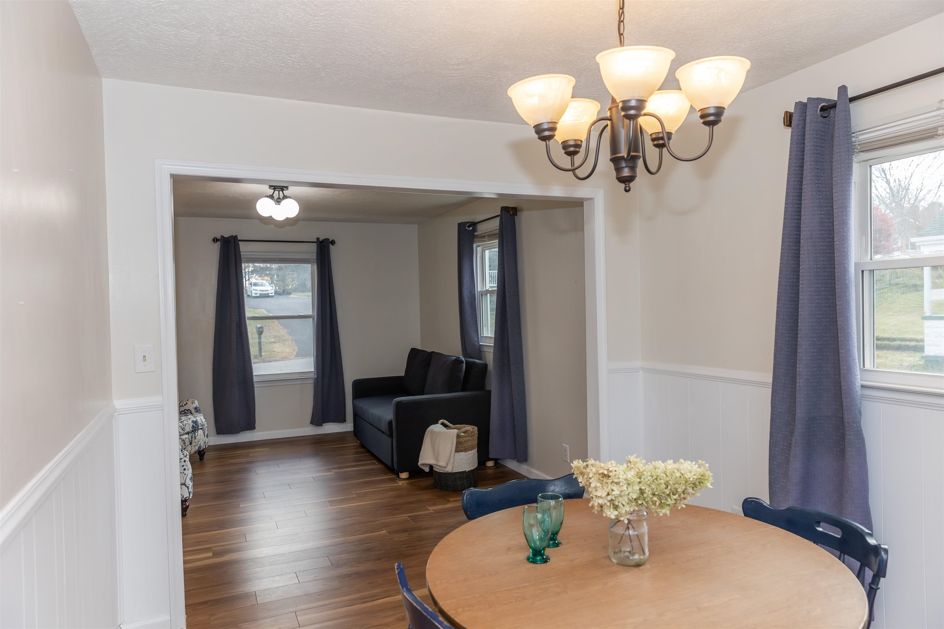 303 Summit Street Lexington, VA 24450 - Photo 21 of 58 a dining room with wooden floor a chandelier a wooden table and chairs