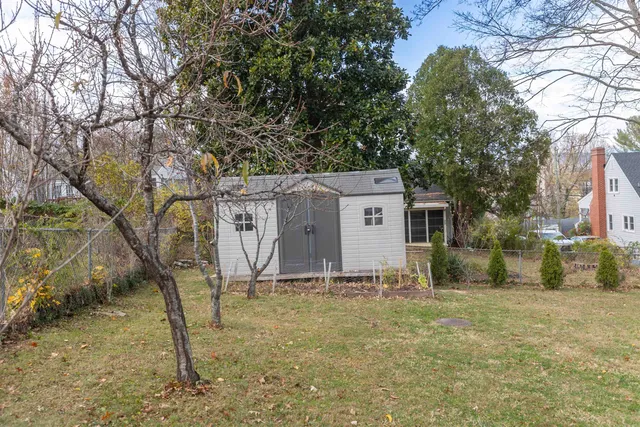 a view of a house with large windows and a tree