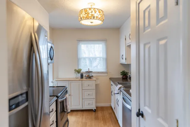 a kitchen with stainless steel appliances a stove a refrigerator and a cabinets
