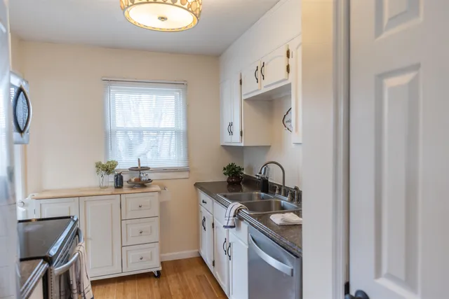 a kitchen with a sink stove top oven and cabinets