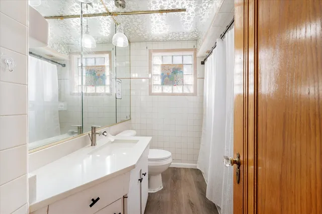 a bathroom with a double vanity sink toilet and shower