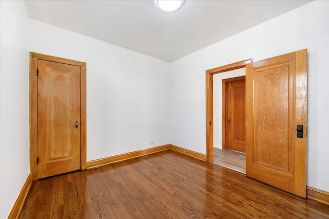 an empty room with wooden floor and closet