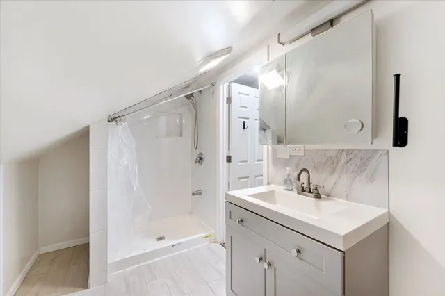 a bathroom with a shower sink and mirror