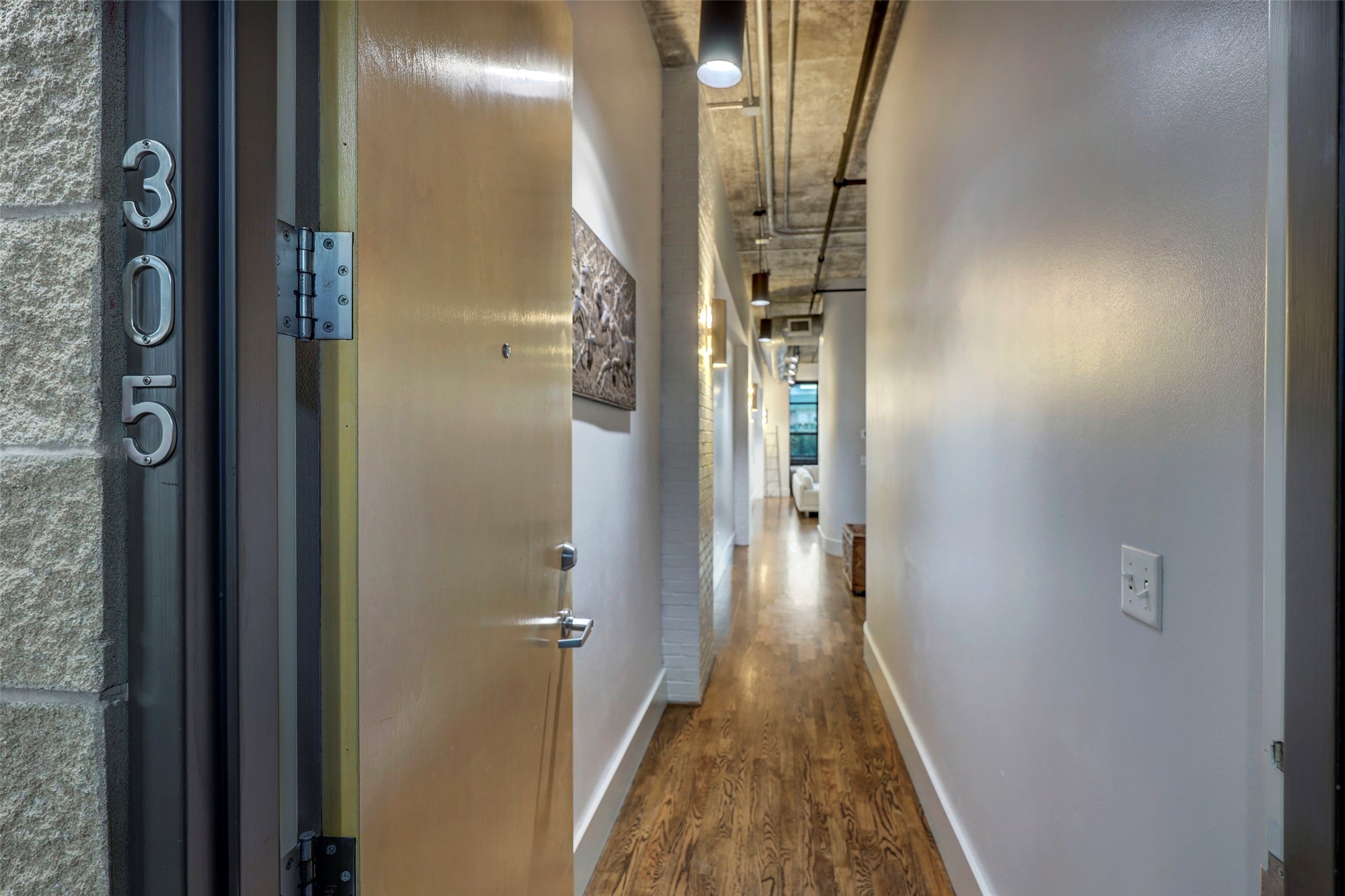 505 Bastrop Street, Unit 305 Houston, TX 77003 - Photo 5 of 15 a view of a hallway with wooden floor