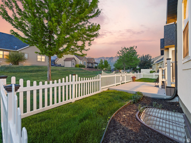 6242 Apollo Way Highland, UT 84003 - Photo 41 of 47 Expansive backyard featuring a white picket fence, concrete patio, and manicured lawn