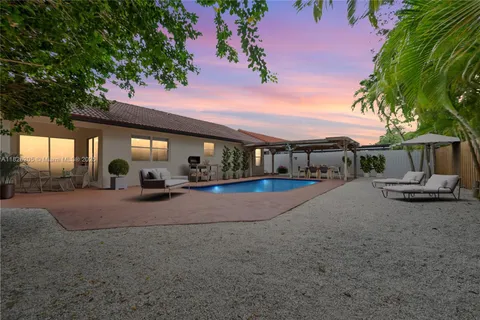a view of a house with backyard and sitting area