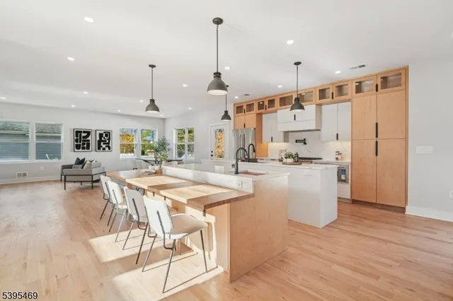 a kitchen with stainless steel appliances kitchen island granite countertop a dining table chairs and white cabinets
