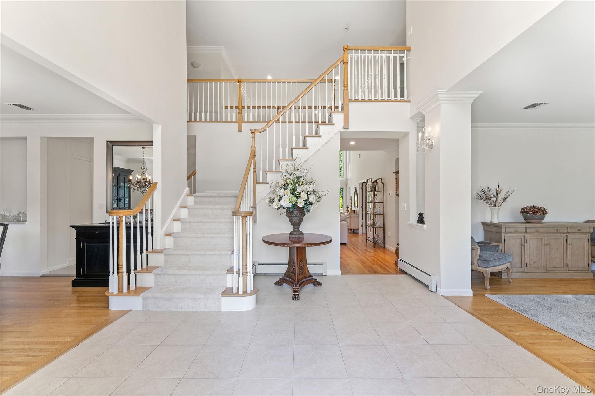 22 Perrin's Peak Road Stony Point, NY 10980 - Photo 18 of 47 Entrance foyer featuring ornamental molding, wood finished floors, a towering ceiling, stairs, and a baseboard radiator