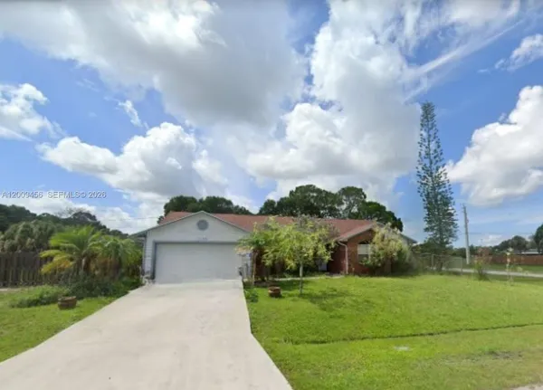 a front view of a house with a yard and trees