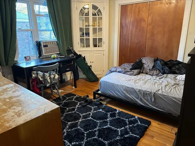 a bedroom with a bed and wooden floor