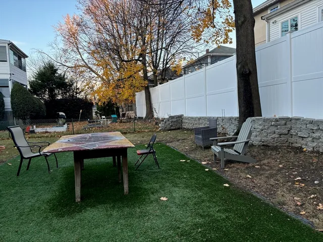 a backyard of a house with table and chairs