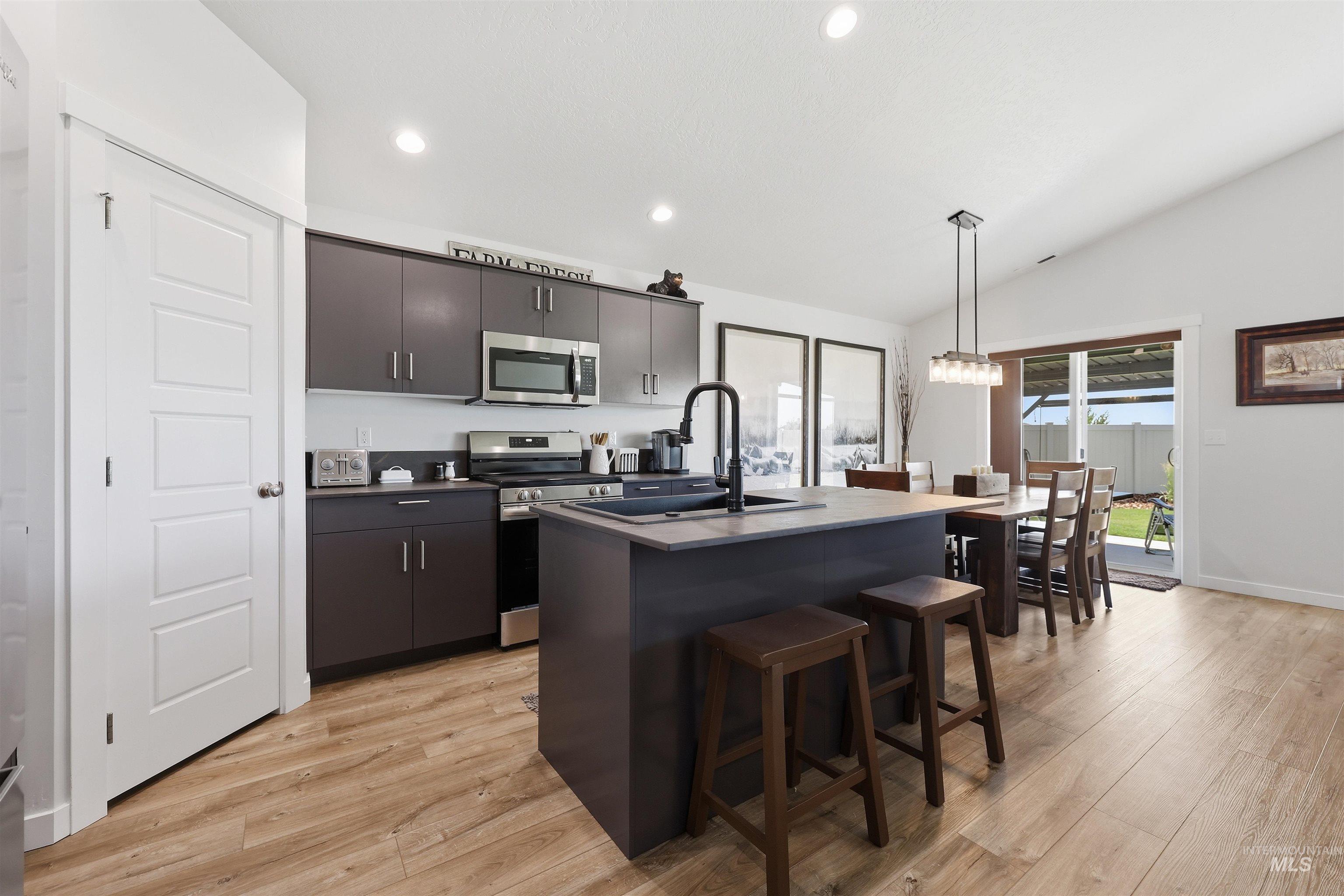 3811 West Maypearl Street Meridian, ID 83642 - Photo 16 of 39 Kitchen featuring wood-finish flooring, recessed lighting, and a vaulted ceiling