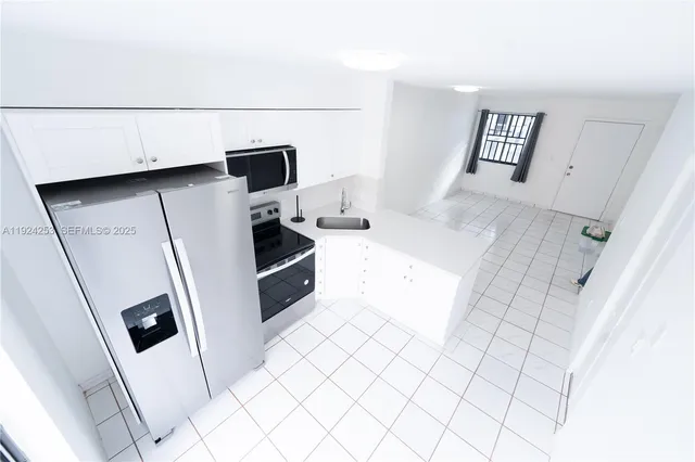 a kitchen with stainless steel appliances a refrigerator and a stove top oven