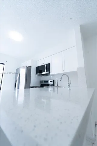 a kitchen with furniture a refrigerator and a sink