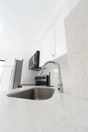 a kitchen with stainless steel appliances a sink a stove and a microwave