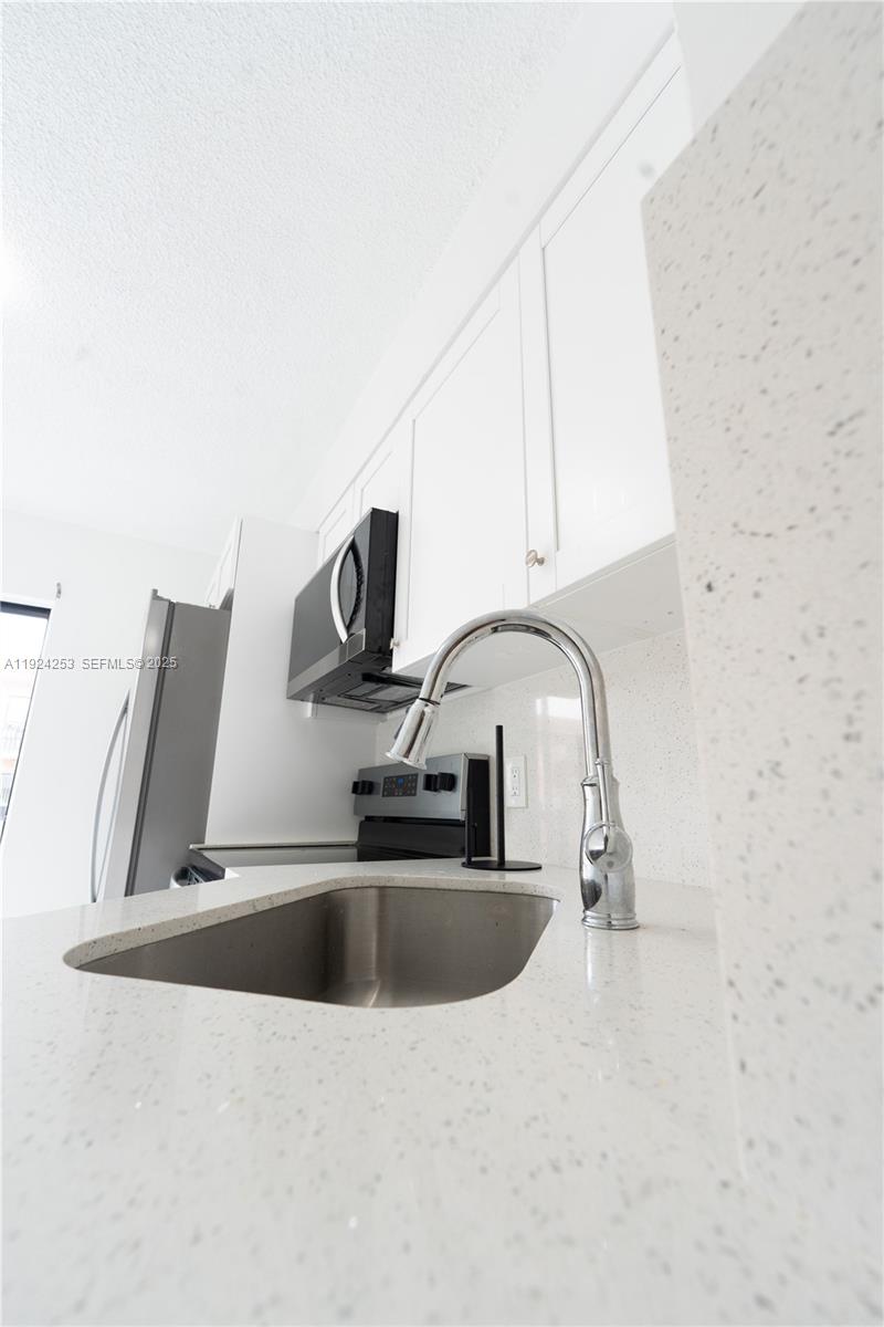 5300 West 21st Court, Unit 311 Hialeah, FL 33016 - Photo 4 of 10 a kitchen with stainless steel appliances a sink a stove and a microwave