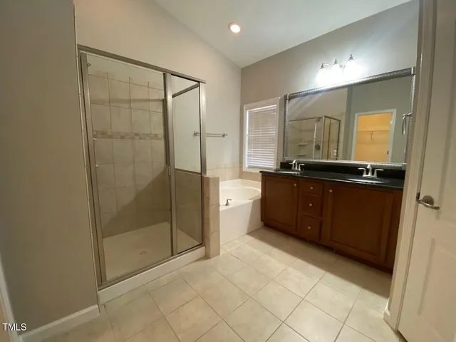 a spacious bathroom with a mirror a shower and vanity