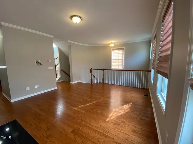 a view of an empty room with wooden floor