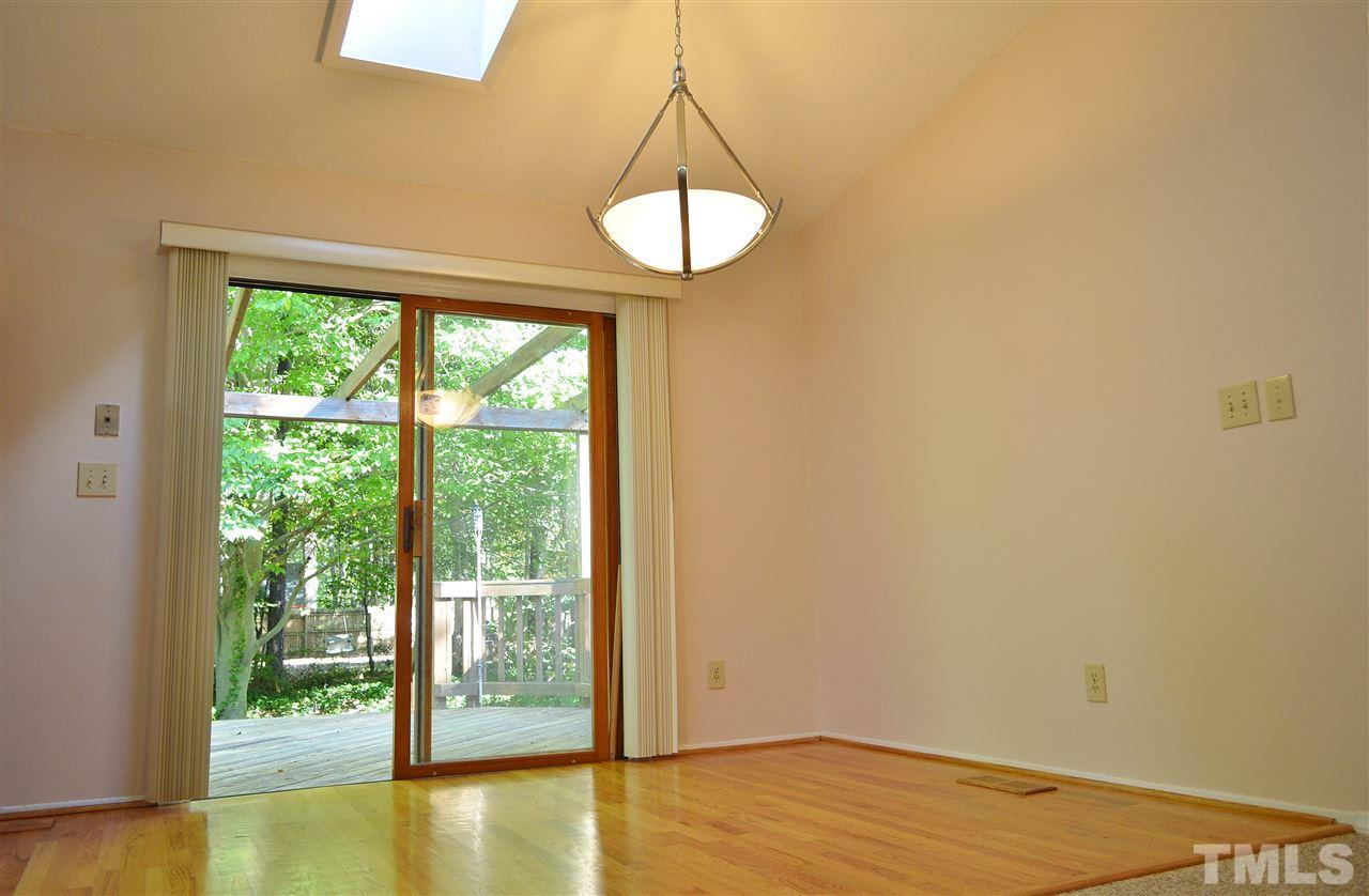 3104 Chancery Place Raleigh, NC 27607 - Photo 6 of 25 The dining room is open to the living room. It has a vaulted ceiling with skylight, hardwood floors, new light fixture and looks out onto the deck.