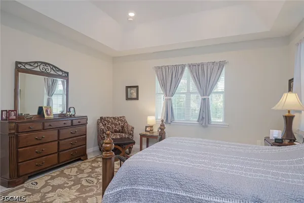 a bedroom with a bed and a mirror on dresser