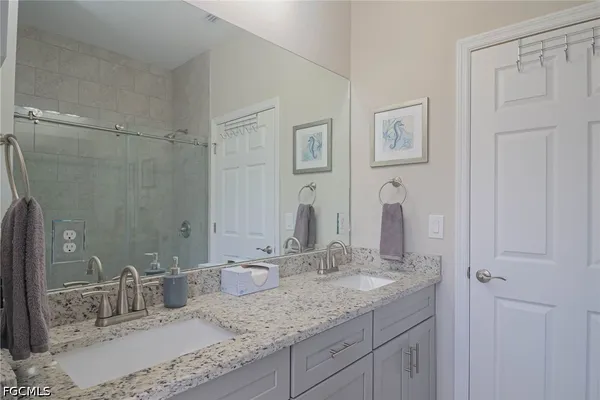 a bathroom with double vanity sinks and a mirror