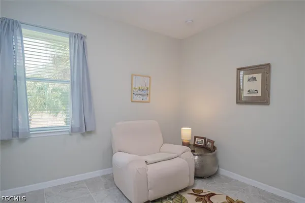 a living room with furniture a window and a lamp
