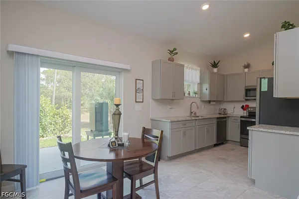 a kitchen with kitchen island a table and chairs in it