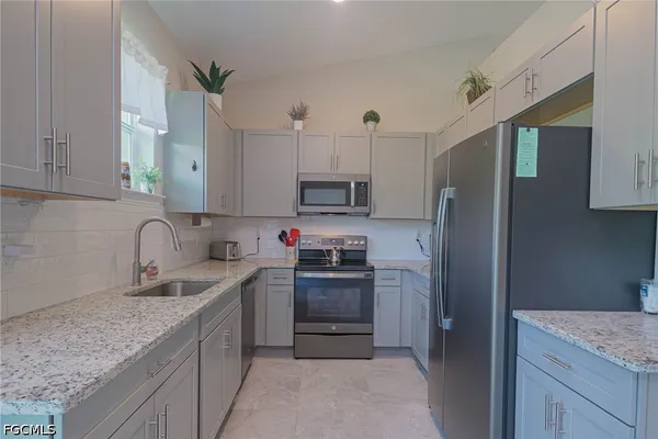 a kitchen with stainless steel appliances granite countertop a sink stove and refrigerator