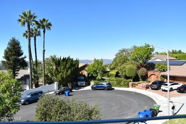 a view of a park with a bench and potted plants