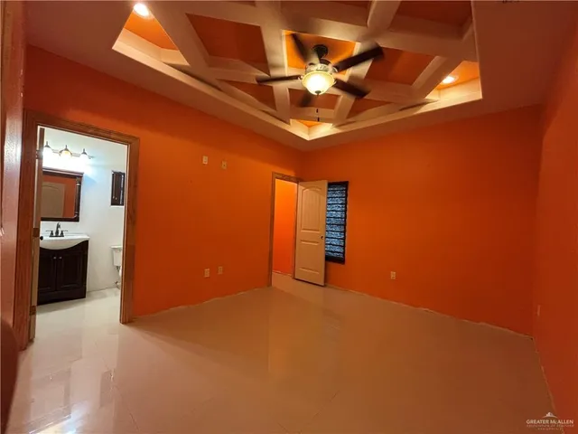 a view of an empty room with a chandelier fan
