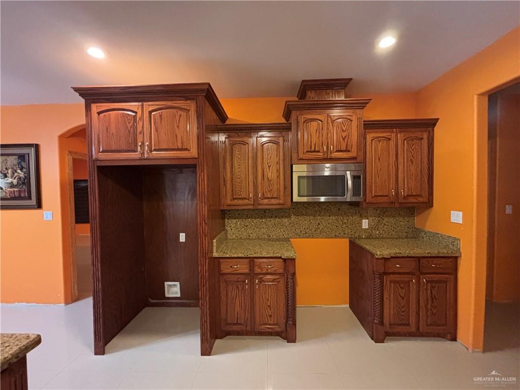 45 Zinnia Street Rio Grande City, TX 78582 - Photo 7 of 31 a kitchen with granite countertop a stove and cabinets