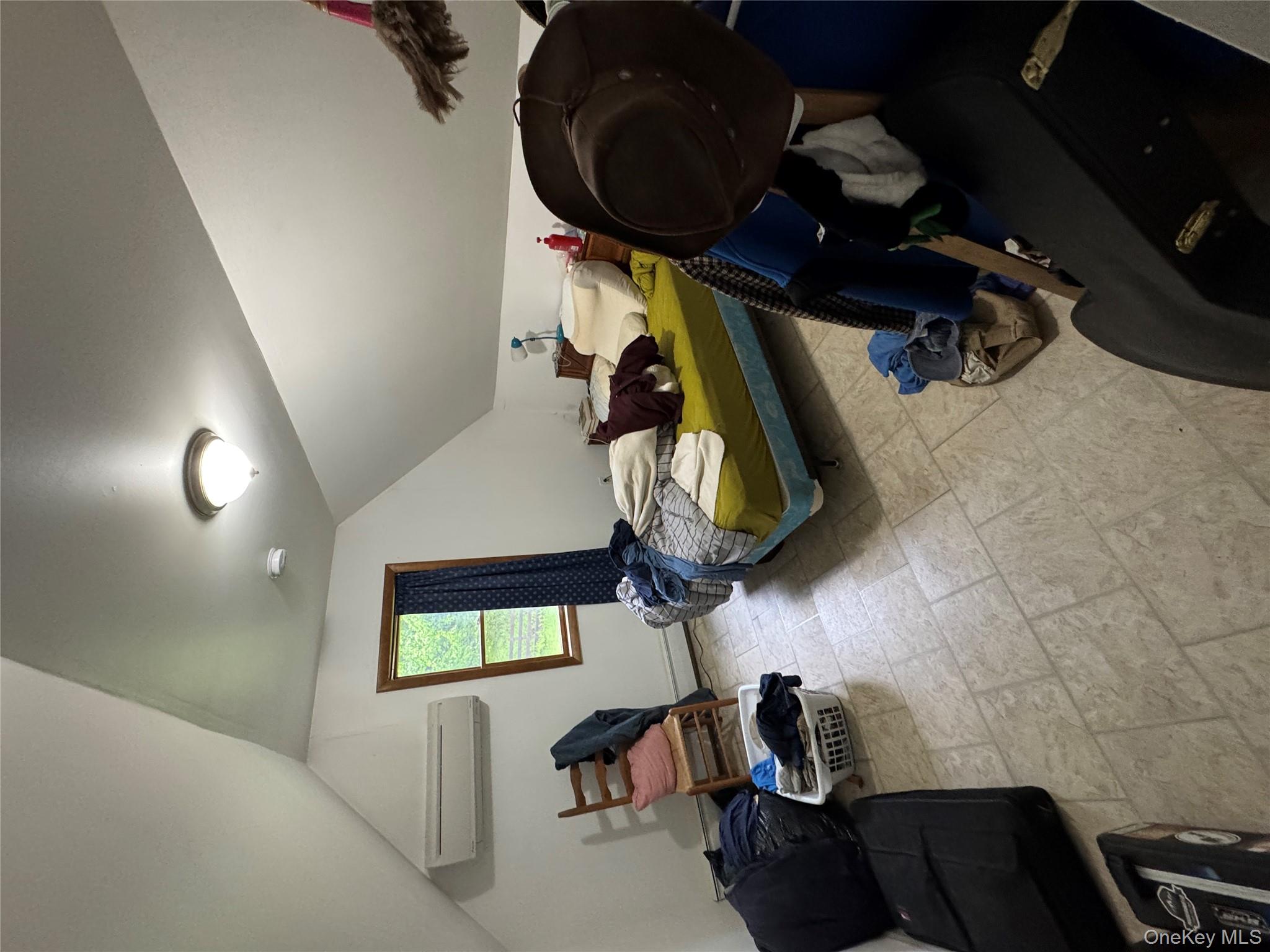405 Burnt Hill Road Roscoe, NY 12776 - Photo 11 of 11 Bedroom featuring an AC wall unit, stone finish floors, vaulted ceiling, and a baseboard heating unit