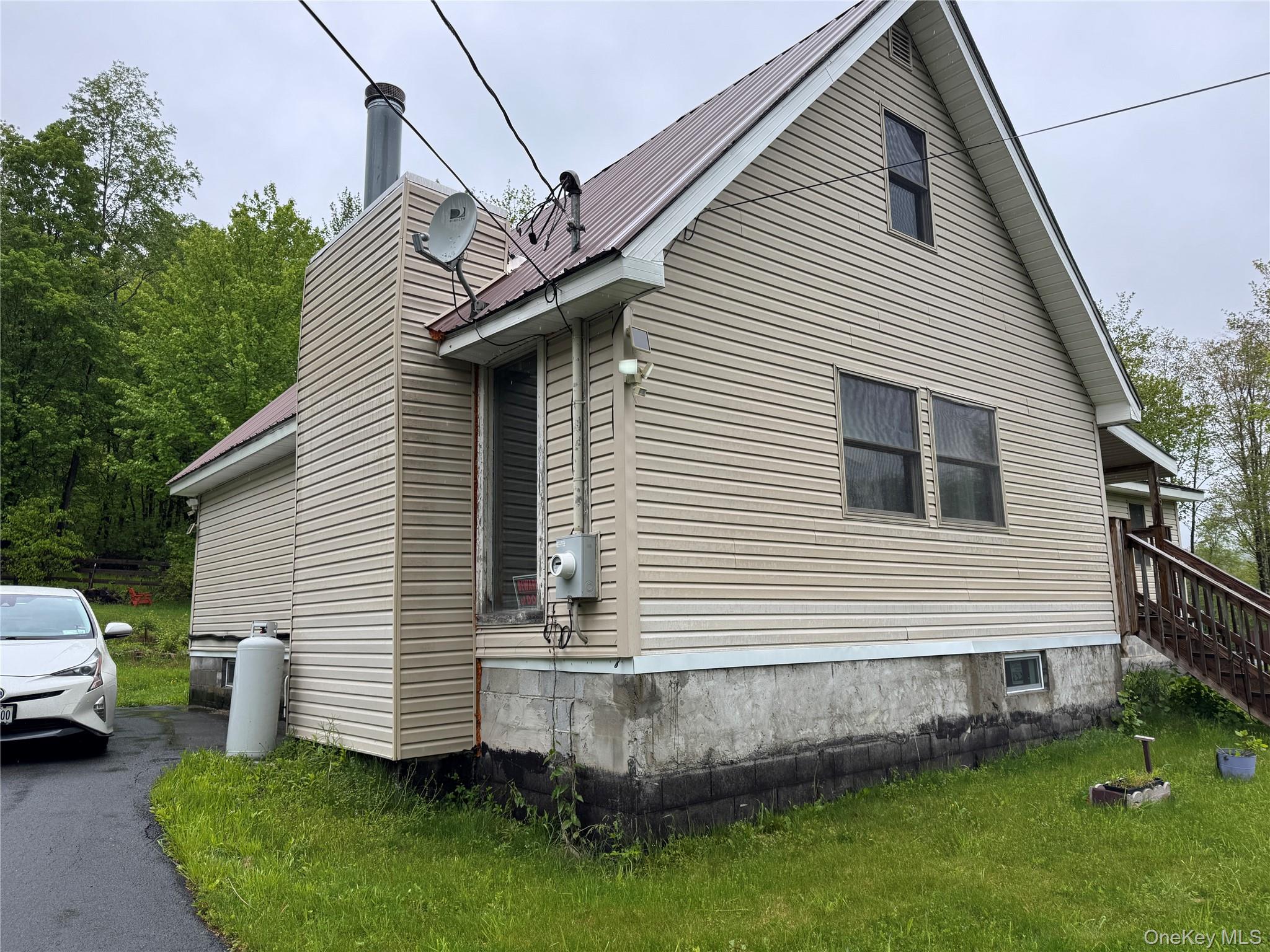 405 Burnt Hill Road Roscoe, NY 12776 - Photo 2 of 11 View of property exterior featuring a chimney, stairs, metal roof, and a lawn