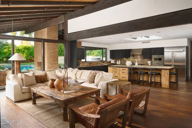 a kitchen with stainless steel appliances kitchen island granite countertop a table chairs sink and cabinets