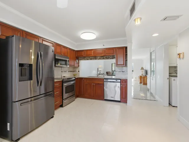 a kitchen with granite countertop a refrigerator and a sink