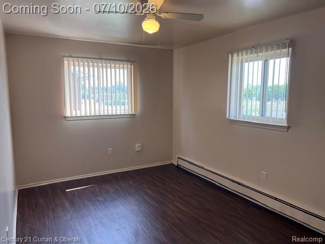 14682 Middle Gibraltar Road, Unit 24 Rockwood, MI 48173 - Photo 12 of 21 Room featuring wood-finish flooring, neutral wall tones, and two windows with vertical blinds