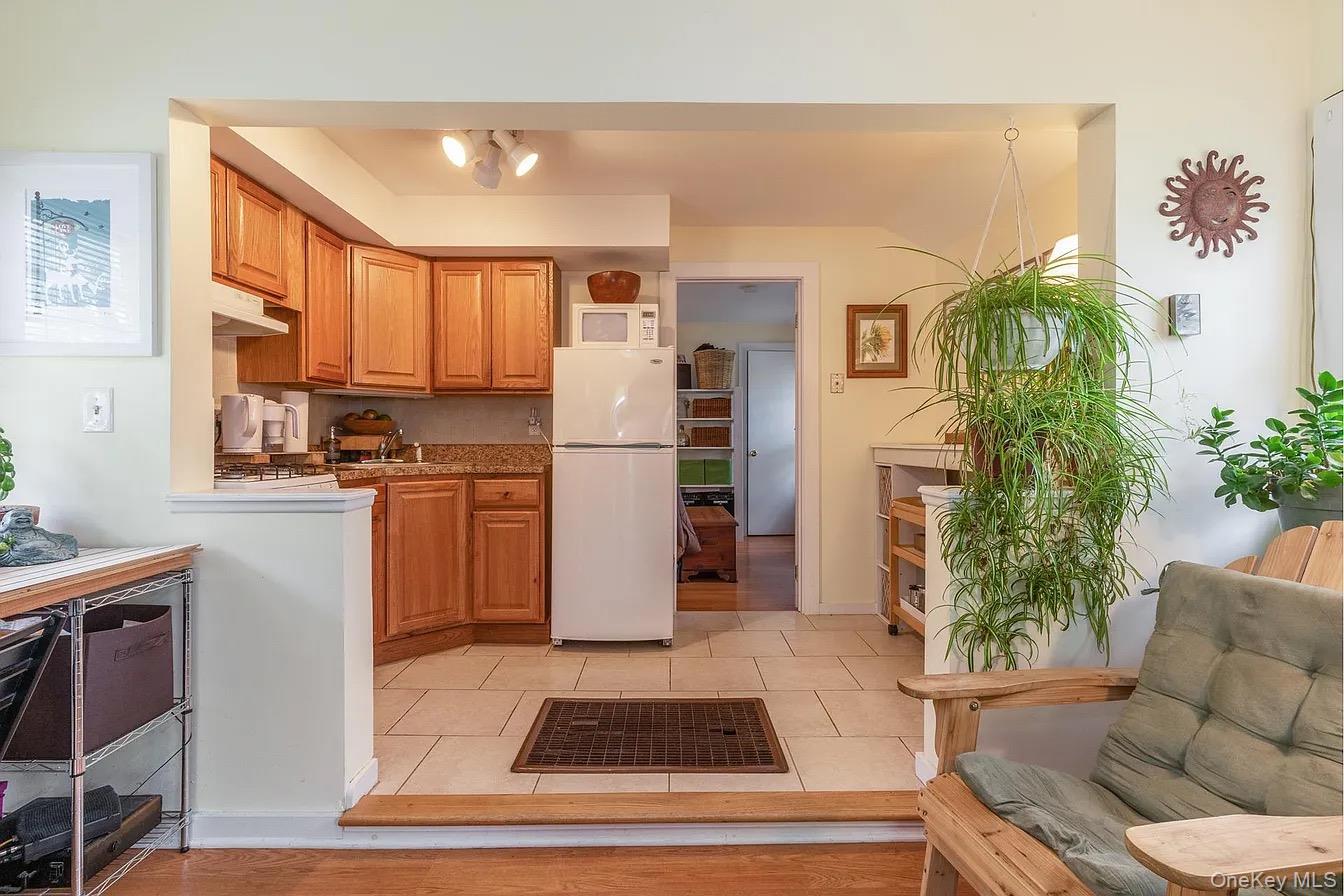 560 Pacific Street Mattituck, NY 11952 - Photo 3 of 7 a living room with furniture a refrigerator and a potted plant
