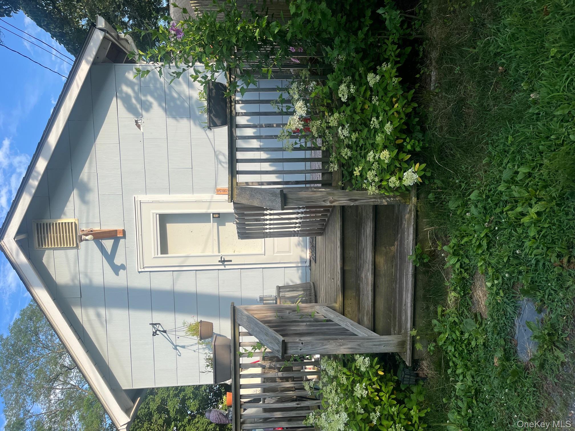 560 Pacific Street Mattituck, NY 11952 - Photo 5 of 7 a front view of a house with a garden