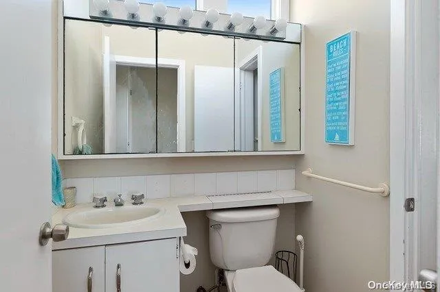a bathroom with a sink toilet and mirror