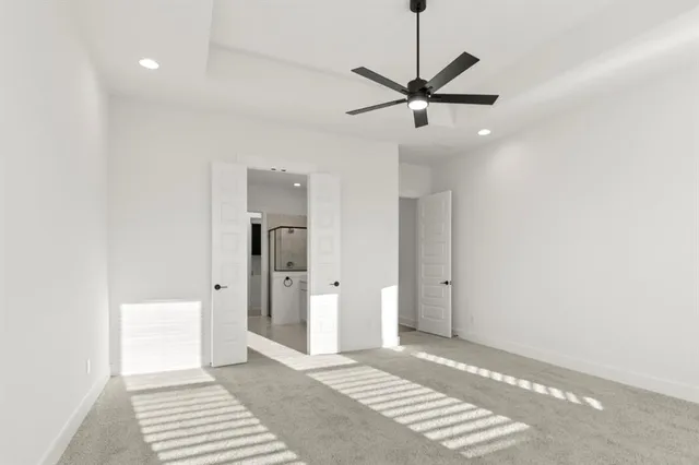 a view of a room with a ceiling fan and entryway