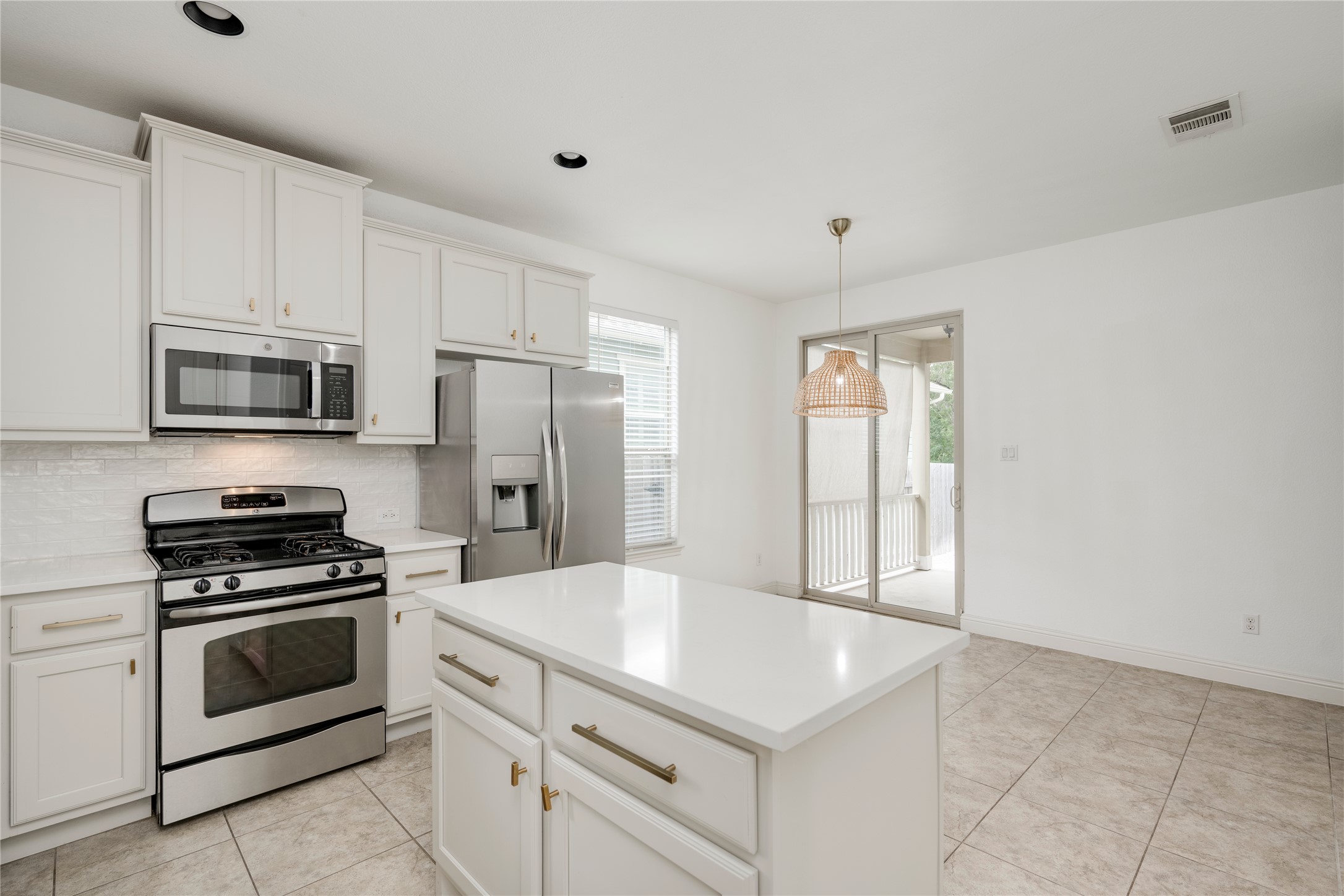 6008 Whipple Way Austin, TX 78745 - Photo 11 of 39 A well-equipped kitchen with a central island and sleek appliances opens to an inviting outdoor space.