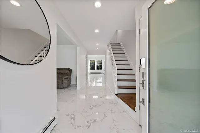a view of a hallway with stairs and wooden floor